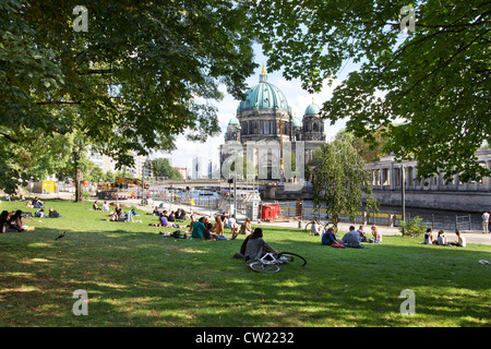 Per coloro che godono nel parco lungo il fiume Spree sulla soleggiata giornata estiva. Berliner Dom è visibile in background Foto Stock