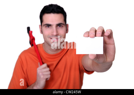 Builder con chiave tenendo business card Foto Stock