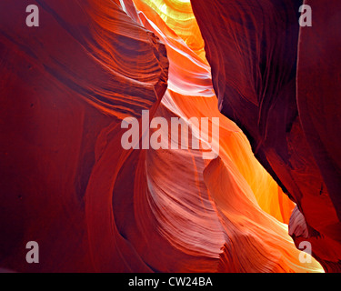 Rosso, arancione e giallo luce solare riflessa su superfici curve e slot a strati la parete del canyon Foto Stock