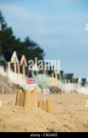 Union Jack Flag in castelli davanti alla spiaggia di capanne. Pozzetti accanto al mare. Norfolk, Inghilterra Foto Stock