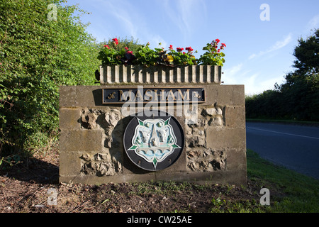 Masham, Wensleydale inferiore borgo in pietra scolpita in pietra marcatore di confine con fiori. North Yorkshire Dales National Parks, REGNO UNITO Foto Stock