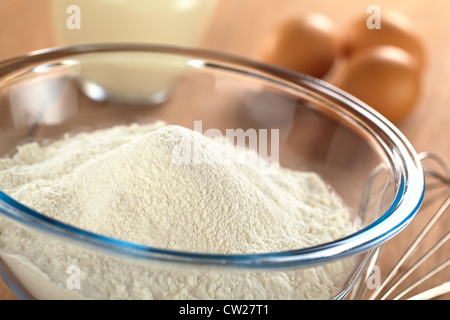 Preparare una pasta/l'impasto per crespelle o frittelle di farina di grano in recipiente di vetro, il latte e le uova nella parte posteriore e un battitore accanto Foto Stock