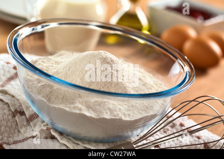 Preparare una pasta/l'impasto per crespelle o frittelle di farina di grano in recipiente di vetro, latte, uova e olio nel retro e il battitore accanto Foto Stock