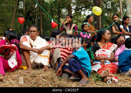 I popoli indigeni compresi donne e bambini si sono riuniti attorno al tempio di locali per guardare il Festival Gajamela in Kerala India Foto Stock