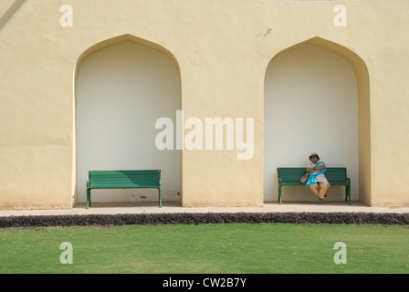 Lone tourist donna seduta su una panchina, Jantar Mantar, Jaipur Foto Stock