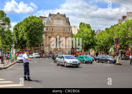 Poliziotto regola il traffico a Place Saint-Michel pubblica piazza davanti a fontana monumentale di Parigi, Francia. Foto Stock