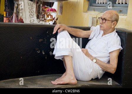 Uomo anziano (comunità ebraica) appoggiato sulla veranda della sua casa di Mattancherry, Fort Kochi in Kerala Foto Stock
