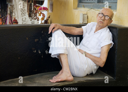 Uomo anziano (comunità ebraica) appoggiato sulla veranda della sua casa di Mattancherry, Fort Kochi in Kerala Foto Stock