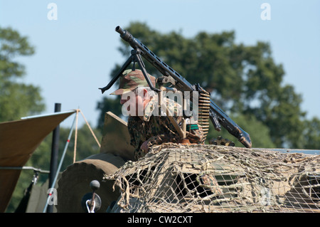 La seconda guerra mondiale la seconda guerra mondiale soldato tedesco in uniforme sulla parte superiore di un veicolo militare con una mitragliatrice a una fiera militare Foto Stock