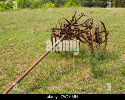 Fattoria arrugginito aratro o aratro trainato da un cavallo in un campo in agriturismo Foto Stock