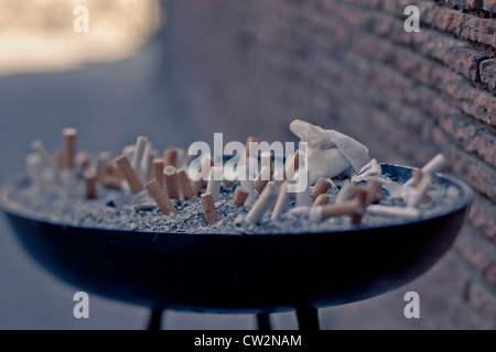 Esterno il portacenere pieno di mozziconi di sigarette Foto Stock