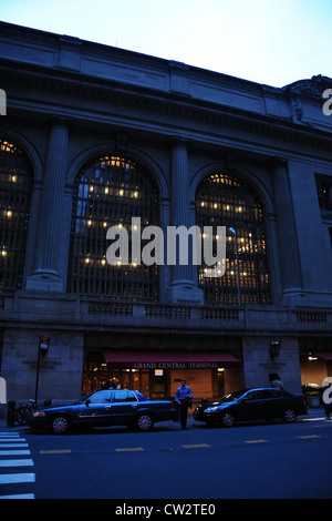 Alba ritratto finestre ad arco, maglietta blu uomo tra 2 auto parcheggiata ingresso Grand Central Terminal Vanderbilt Avenue, New York Foto Stock