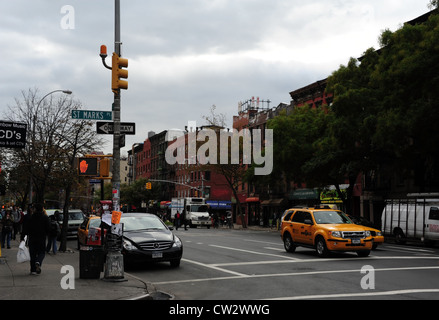 Cielo grigio autunno alberi, auto, giallo taxi, marciapiede persone, tenements, 1° Avenue a Piazza San Marco, East Village, New York Foto Stock