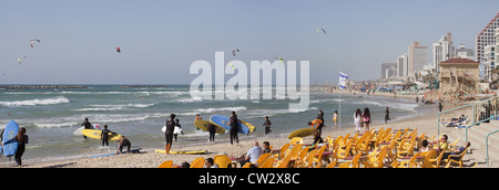 Scena panoramica di surfers entrata in acqua lungo la spiaggia di Tel Aviv, Israele Foto Stock