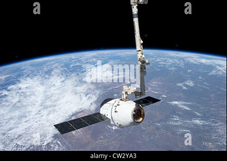 SpaceX Dragon commerciale cargo craft agganci dal Canadarm2 braccio robotico presso la Stazione Spaziale Internazionale vista terra Foto Stock