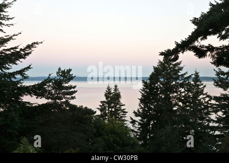 La luce riflessa bagna acqua e cielo sopra di Bellingham Bay con rosa tenue bagliore come sole sorge Bellingham Washington Foto Stock