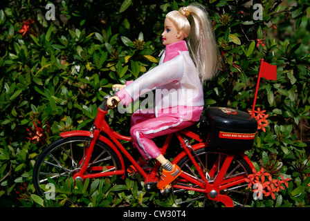 Bambola Barbie girl ciclo di equitazione.Toy girl bicicletta Passeggiate attraverso il giardino panorama concetto di giocattolo storie per bambini Foto Stock