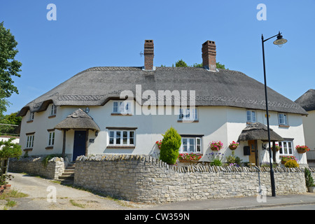 Moderno cottage con il tetto di paglia, strada principale, Tolpuddle, Dorset, England, Regno Unito Foto Stock