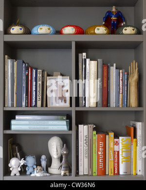 Libreria con libri in una casa contemporanea in Italia con bambole Foto Stock