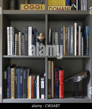 Libreria con libri in una casa contemporanea in Italia con bambole Foto Stock