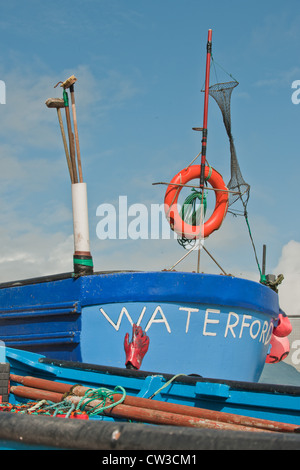 Un dipinto luminosamente barca da pesca trovati sul porto di Ardmore in Irlanda. Foto Stock