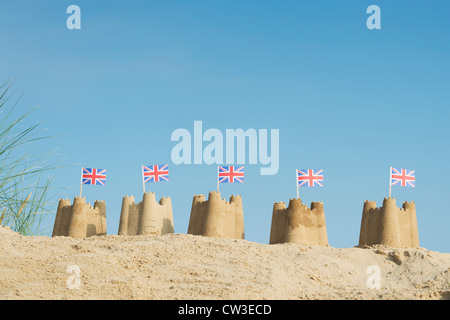 Union Jack Flag in castelli su una duna di sabbia. Pozzetti accanto al mare. Norfolk, Inghilterra Foto Stock