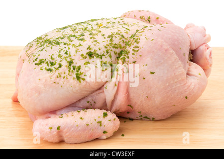 Un fresco di pollo crudo su un tagliere di legno - studio shot Foto Stock