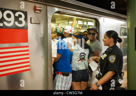 I festaioli affollano il numero Un treno dopo la giornata Dominicana Parade di New York Foto Stock