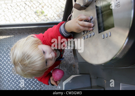 Berlino, un bimbo al telefono in una cabina telefonica Foto Stock