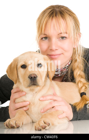 Il Labrador Retriever. Cucciolo di colore giallo che giace accanto al sorridente giovane donna. Studio Immagine contro uno sfondo bianco Foto Stock