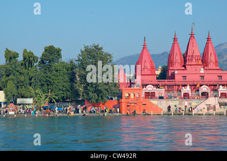 Pellegrini la balneazione nel fiume Gange accanto a un tempio indù. Kumbh Mela Festival 2010, Haridwar, India. Foto Stock