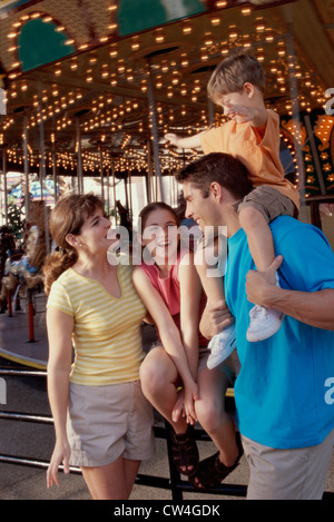 I genitori con il figlio e la figlia in un parco di divertimenti Foto Stock