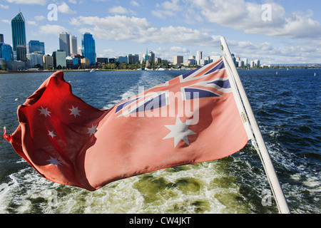 Fiume Swan Perth Western Australia - Australian Red Ensign volato su una barca dalla quale si diparte la città di Perth Foto Stock