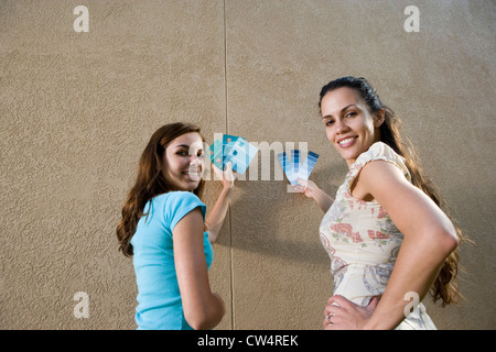 Ritratto di sorelle tenendo i campioni di colore contro la parete Foto Stock