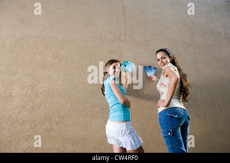 Ritratto di sorelle tenendo i campioni di colore contro la parete Foto Stock