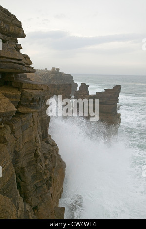 Oceano atlantico spruzza acqua sulle rocce a Cruz dos Remedios, vicino Peniche, costa ovest del Portogallo Foto Stock