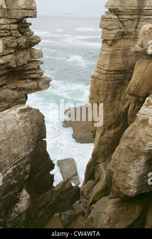 Oceano atlantico spruzza acqua sulle rocce a Cruz do Remedios, vicino Peniche, costa ovest del Portogallo Foto Stock