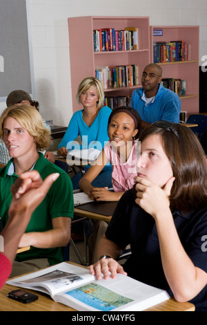 Gli studenti seduti e di ascolto in classe Foto Stock