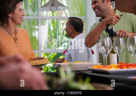 Uomo maturo e una donna matura guardando ogni altro con un altro uomo maturo in piedi in background Foto Stock