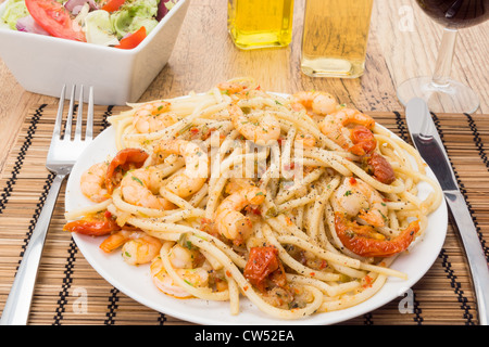 Gamberoni lanciata attraverso i bucatini pasta e guarnita con pomodori secchi - studio shot Foto Stock