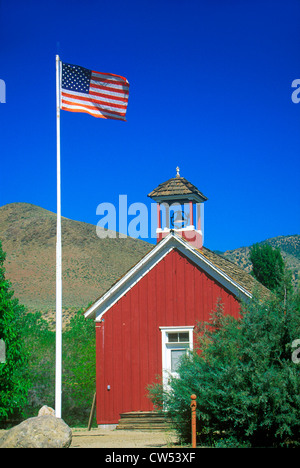 Bandiera americana sventolare sopra una stanza schoolhouse, Wellington, NV Foto Stock