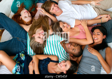 Stati Uniti d'America, New York City, Manhattan, gruppo di amici adolescenti giacente sul letto Foto Stock