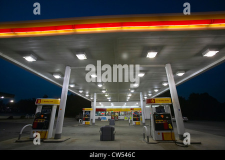 Stazione di gas con le luci accese e mini-mart al tramonto nel centro di GA Foto Stock