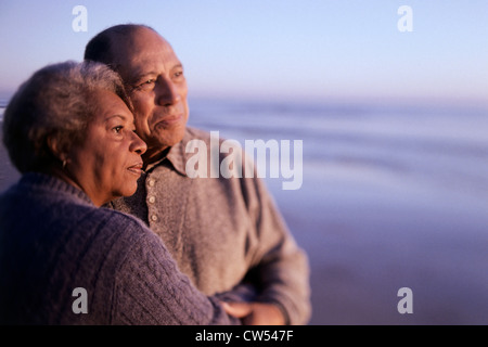 Coppia senior che abbraccia ogni altro sulla spiaggia Foto Stock