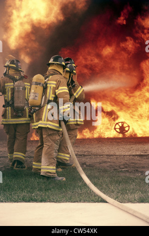 Vista posteriore di un gruppo di vigili del fuoco in caso di incendio Foto Stock