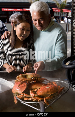 Coppia matura guardando i granchi essendo cotti in un ristorante, Fisherman's Wharf di San Francisco, California, Stati Uniti d'America Foto Stock