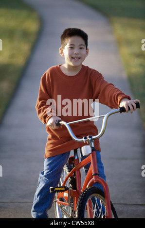 Ritratto di un ragazzo seduto su una bicicletta Foto Stock