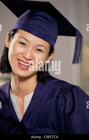 Ritratto di una giovane donna che indossa un abito di graduazione sorridente Foto Stock