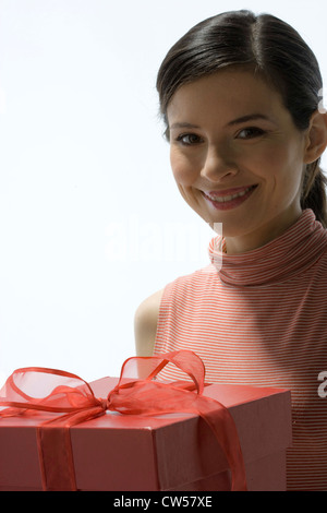 Ritratto di una giovane donna tenendo un dono e sorridente Foto Stock