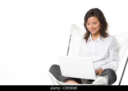 Donna al lavoro su un notebook e sorridente Foto Stock